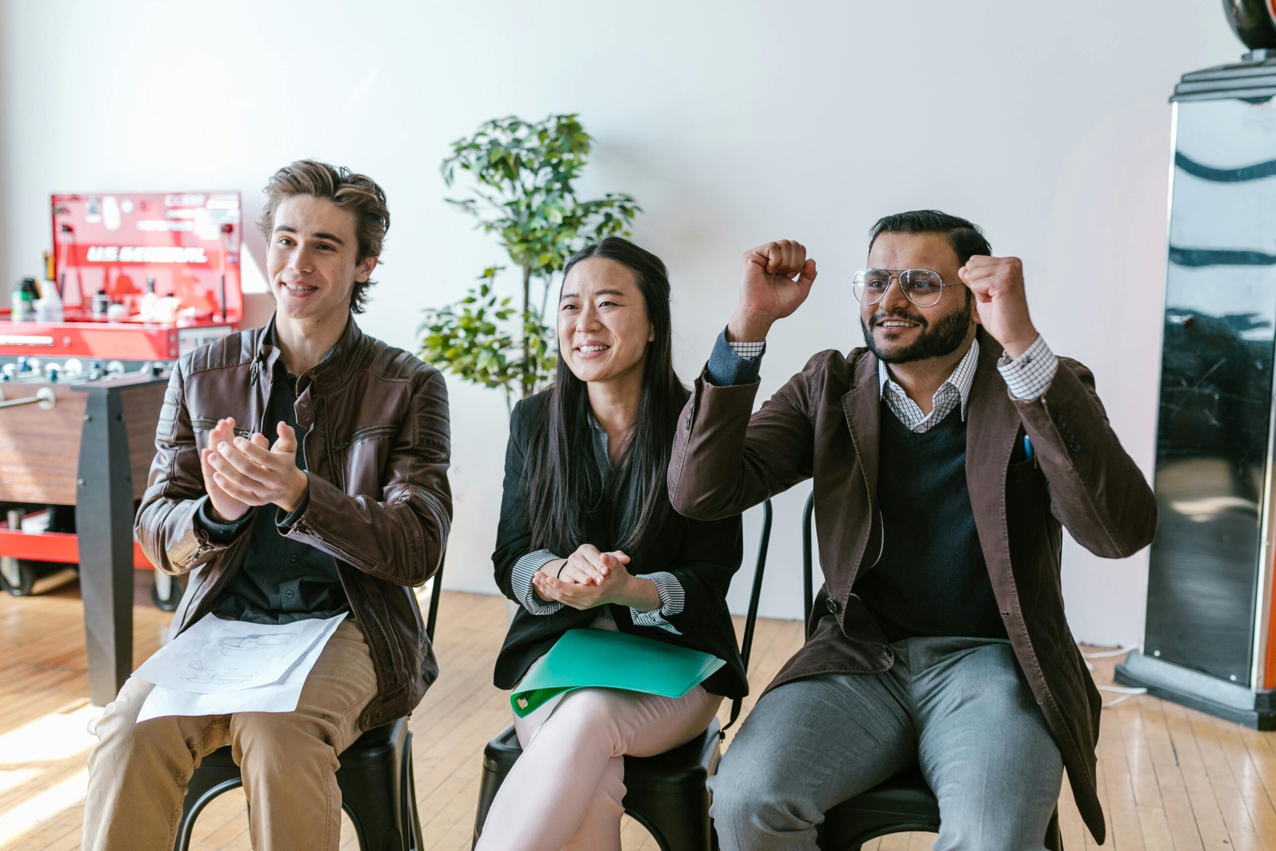 Three professionals celebrating a business achievement, reflecting the success of fintech infrastructure in fast-growing companies.