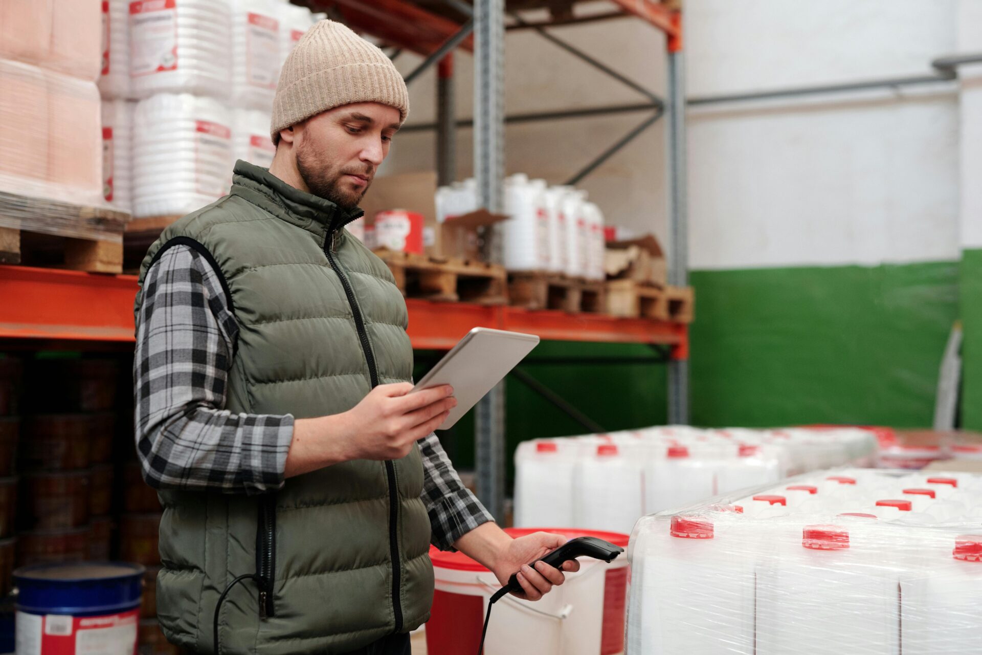 Man checking product inventory with a scanner and tablet, highlighting the importance of inventory loan solutions for businesses.