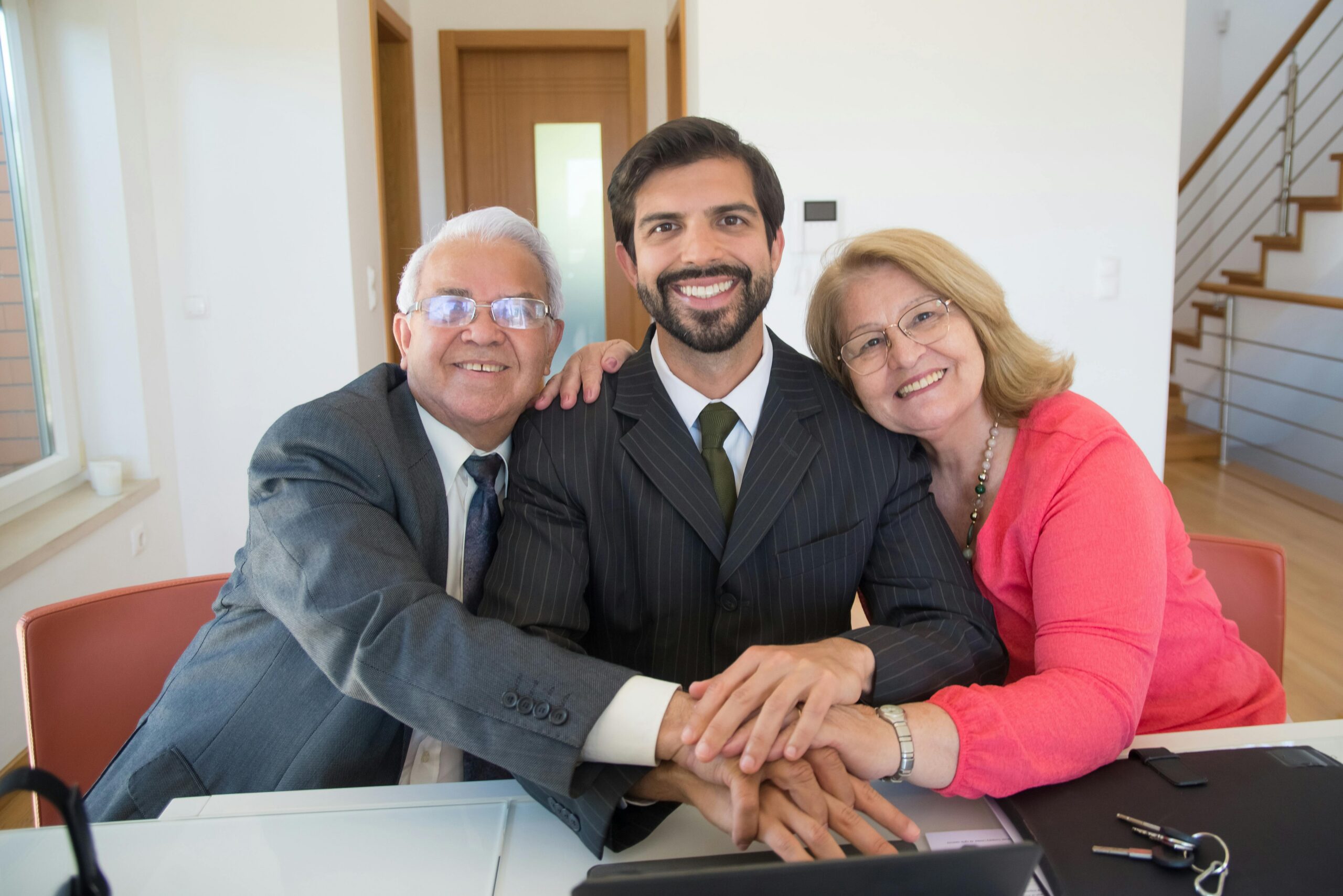 Three family members in formal wear celebrating a milestone during their family business succession journey.