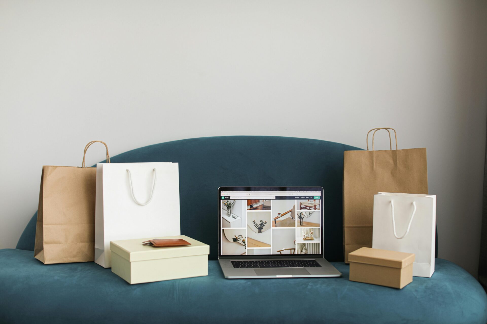 Laptop displaying an online store beside shopping bags and packaging supplies, representing ecommerce working capital needs for growing online businesses.